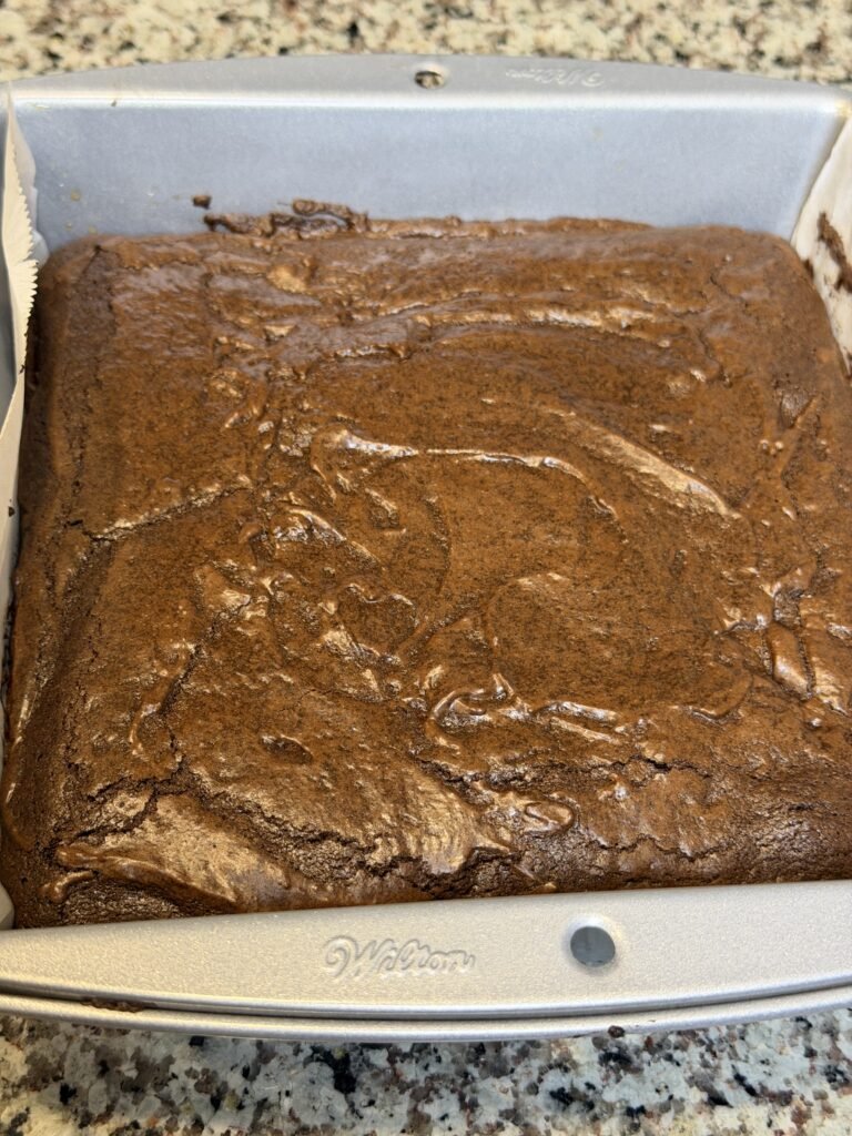 Brownie in a 9x9 in a baking pan cooling.