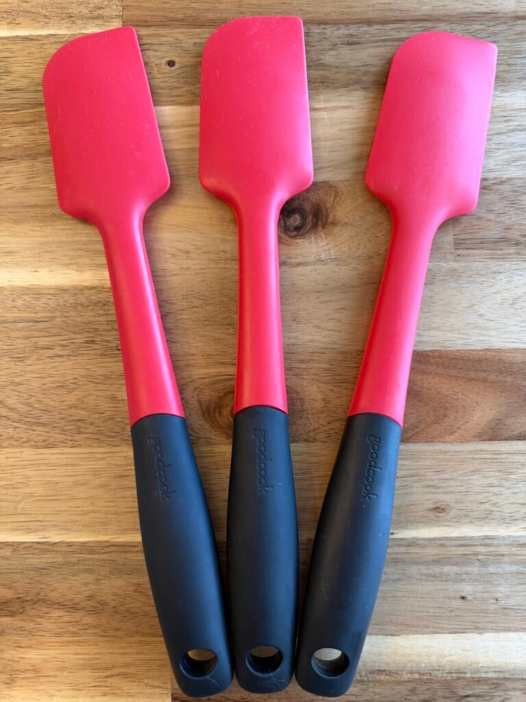 three red & black Good Cook silicone spatula's on a table top.